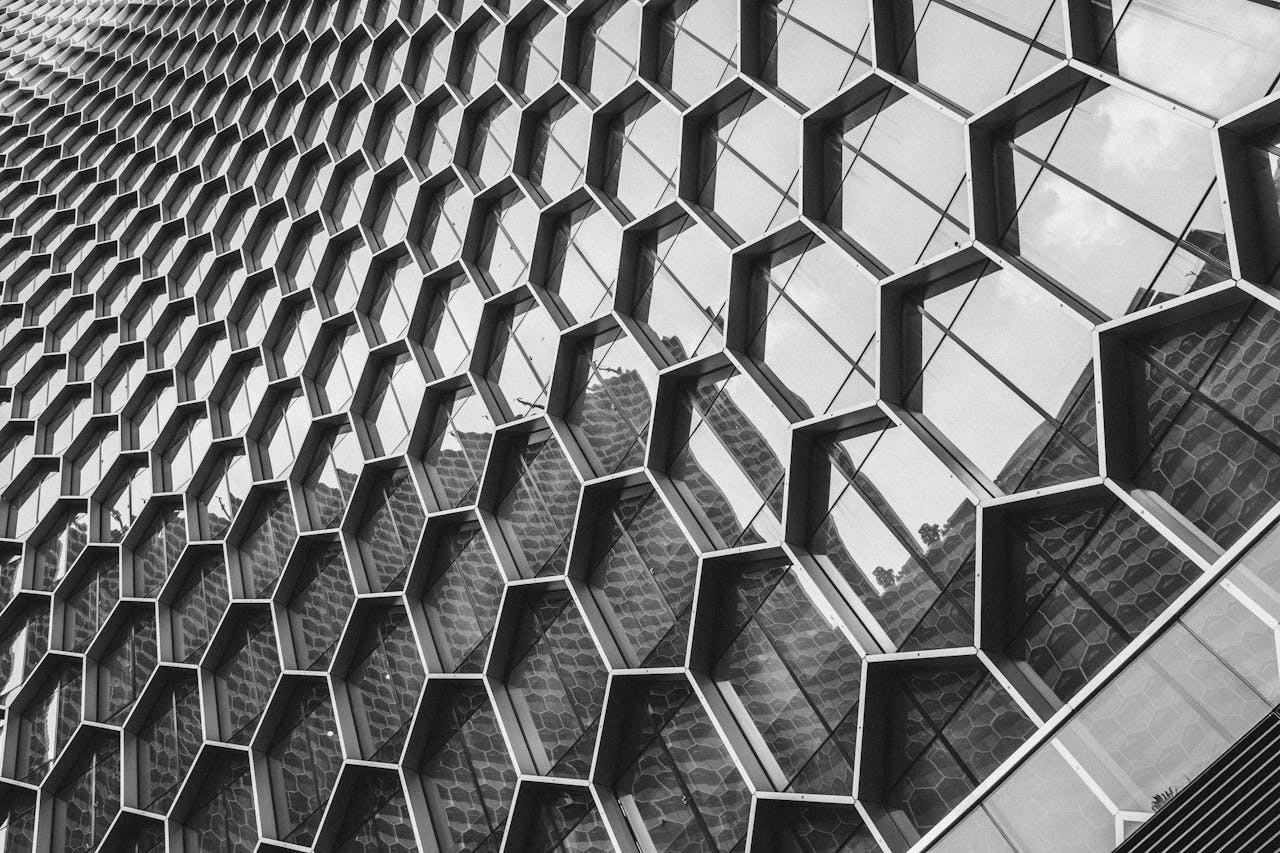 Black and white image of a modern building facade with a geometric hexagonal pattern.